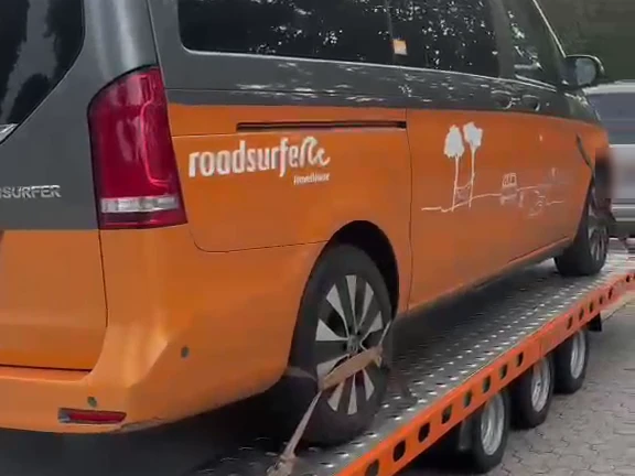 Camper-Van festgezurrt auf dem Autotransportanhänger