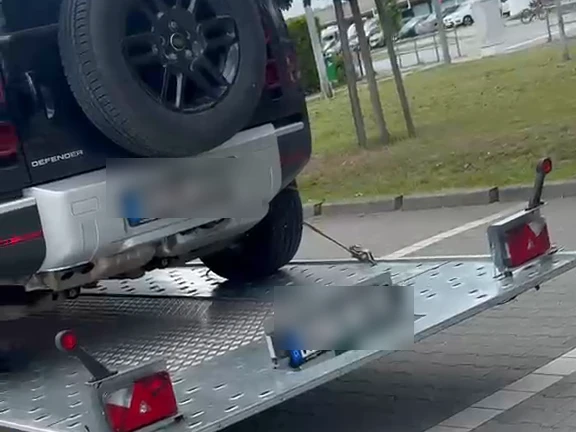 Land Rover Defender festgezurrt auf dem Autotransportanhänger